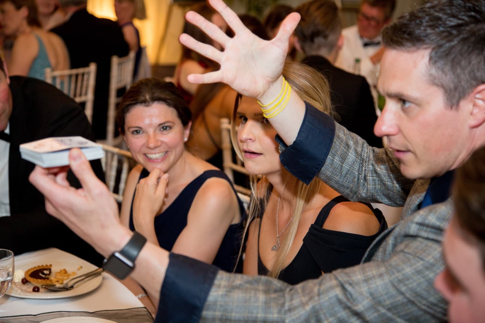James Anthony revealing a playing card to guests at a party