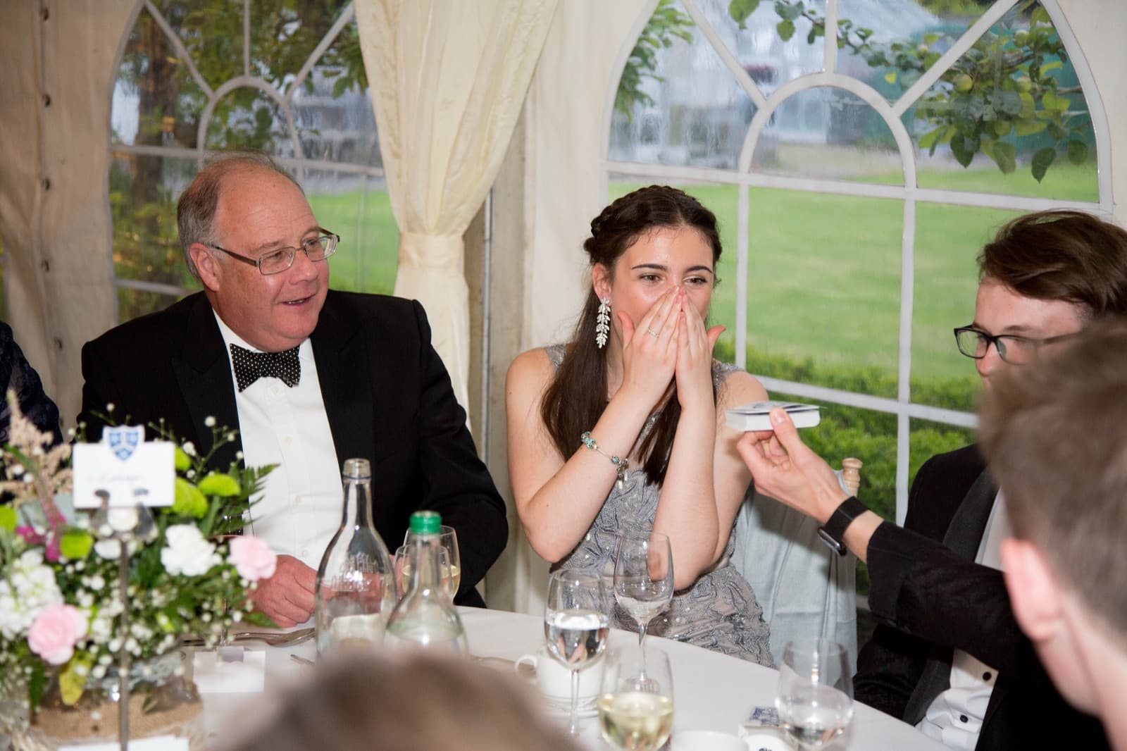 A guest's shocked reaction at a prom dinner in a marquee