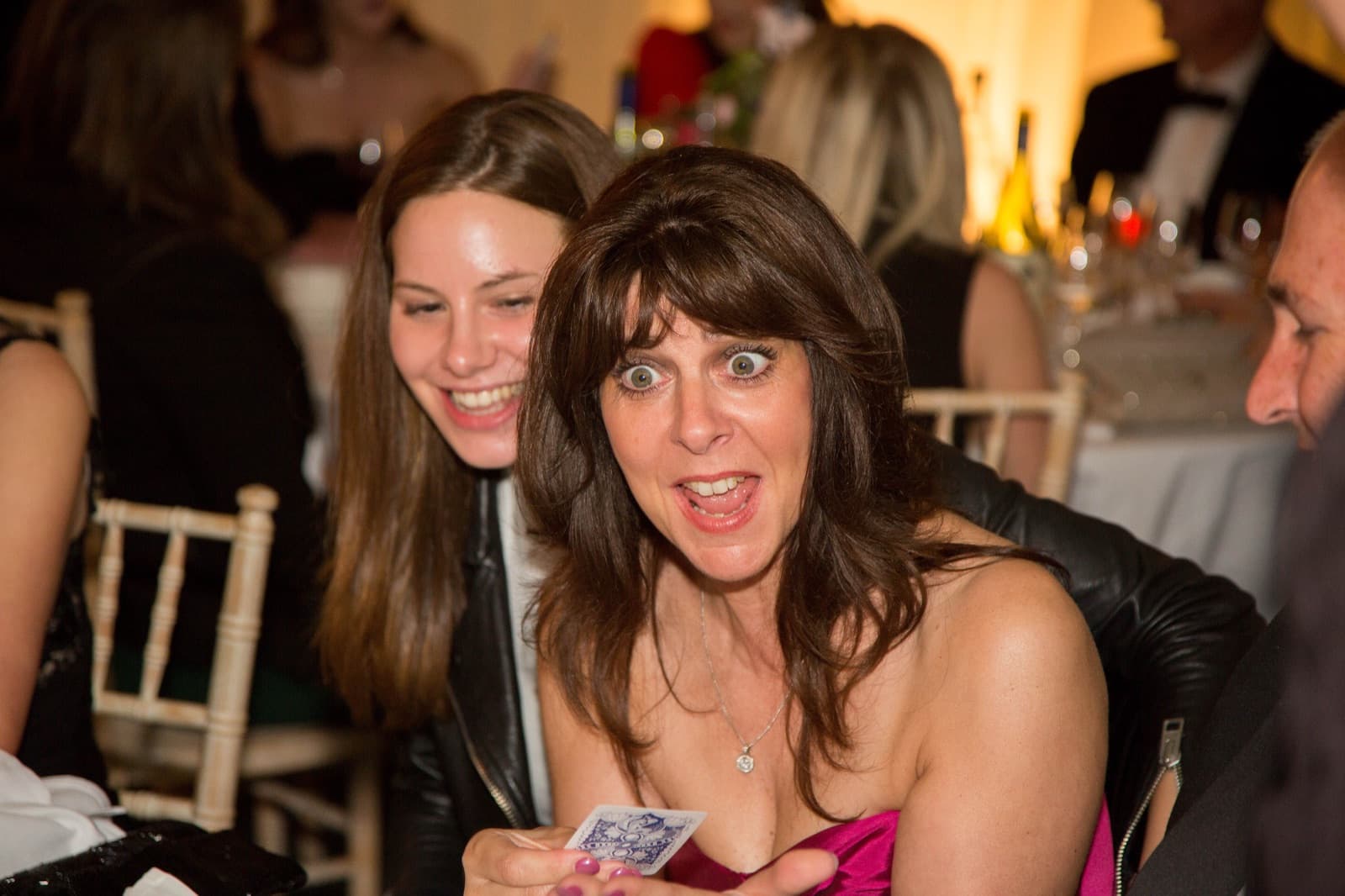 Guests enjoying a magic trick at a prom dinner