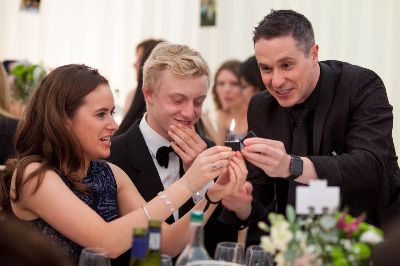James Anthony performing card magic for guests at a party table