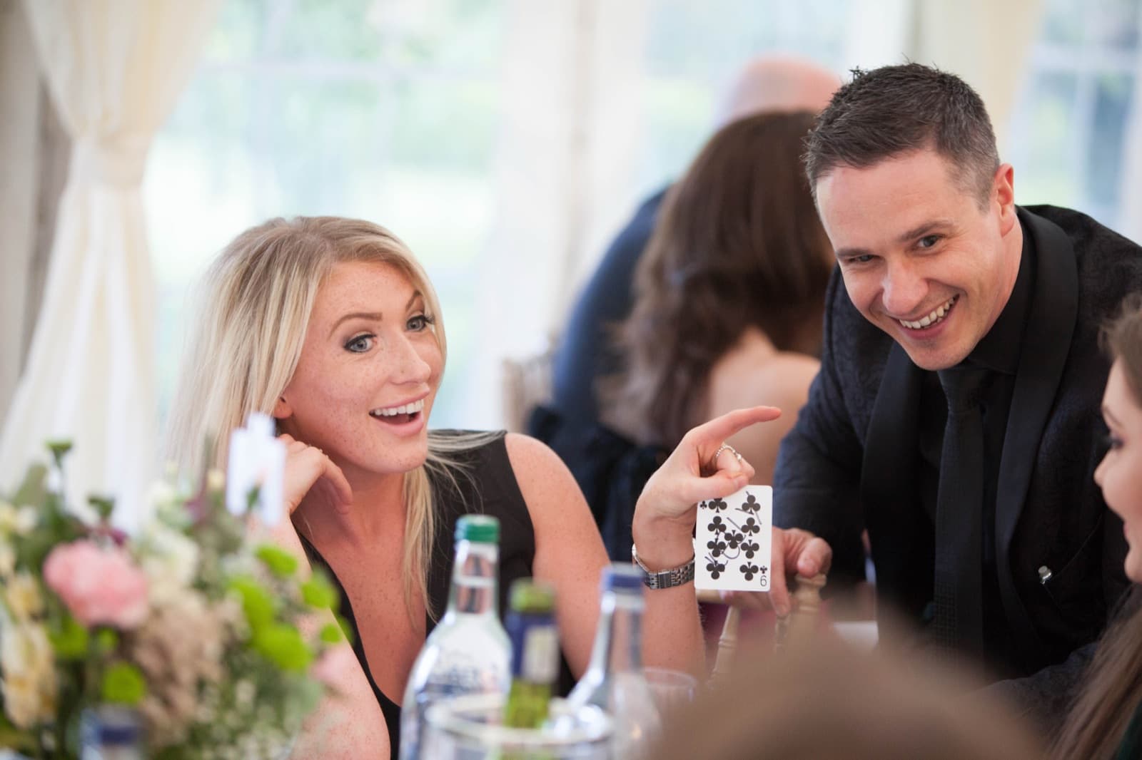 James Anthony performing a card trick for a table of prom guests