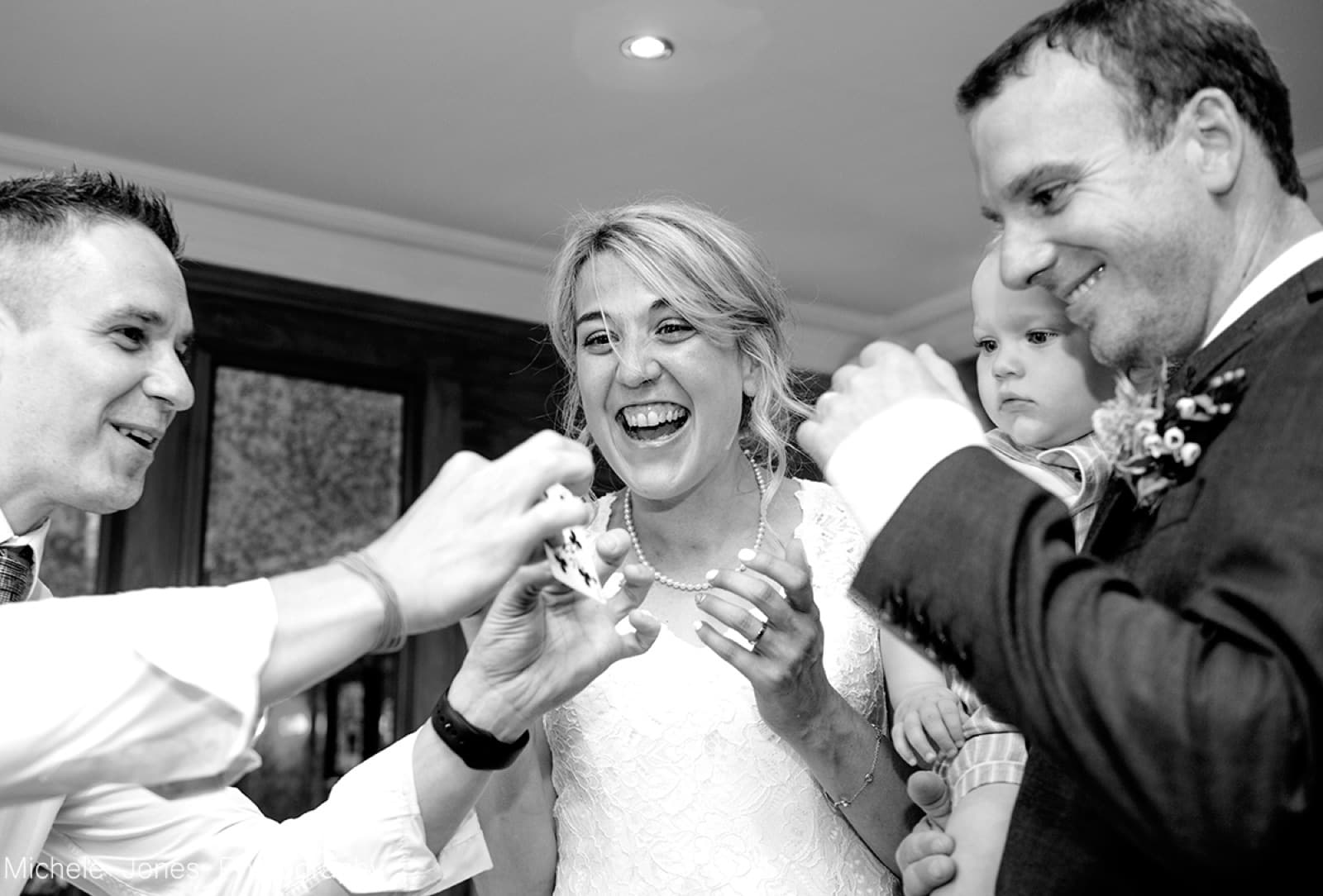 James Anthony performing a card trick for a bride and groom at their wedding reception
